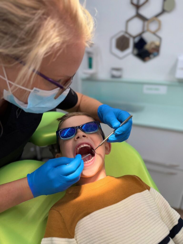 A child in the dentist's chair having their teeth checked.